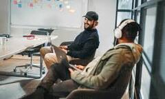 Happy male programmers working together in a boardroom. Using ...