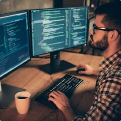 Two Men Sitting In Front Of Computer Screens