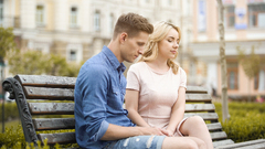 Awkward Couple Sitting On A Bench