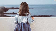 Liitle Girl Holding On White Concrete Fence